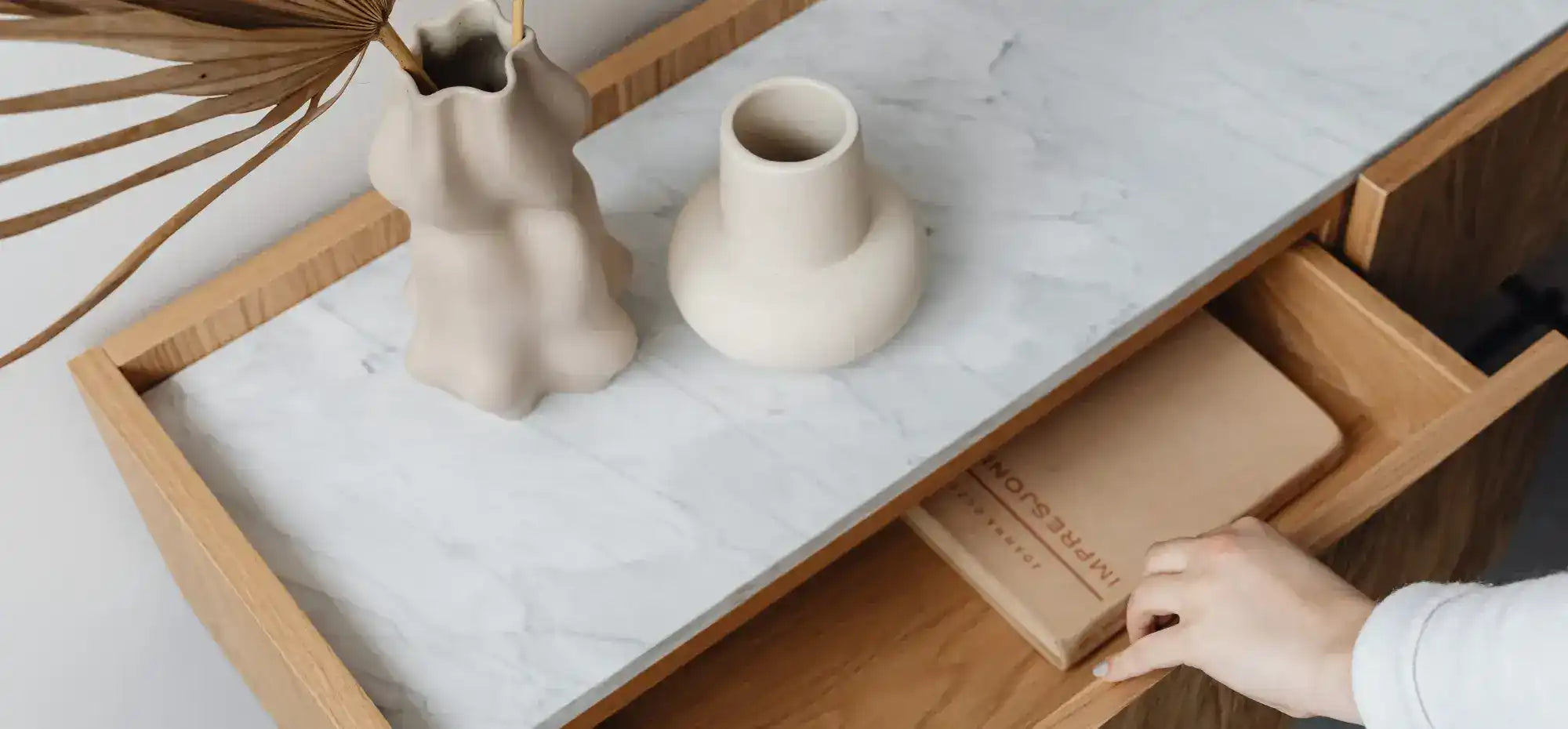 Mesa de madeira com tampo de mármore e gaveta aberta.